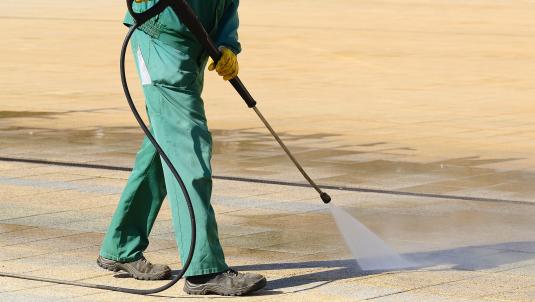 Street cleaner jet washing the pavement
