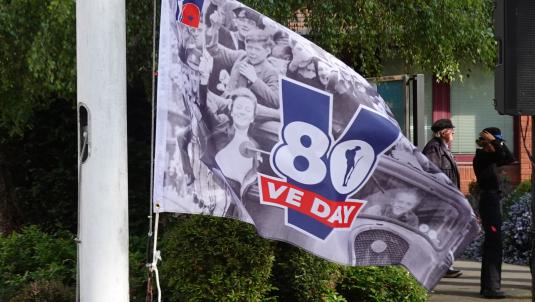 Close up of VE Day 80 flag on pole
