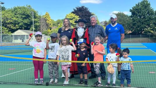 Group of children with the Mayor, consort, and representatives of LTA and NTA on a tennis court
