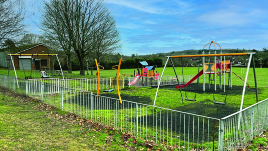 Frimley Green playground with swings, slide and other equipment