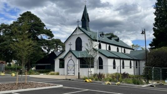 White church, cap parking spaces in foreground