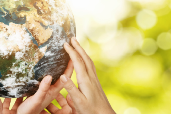 [Multiple hands holding up a model of the Earth]