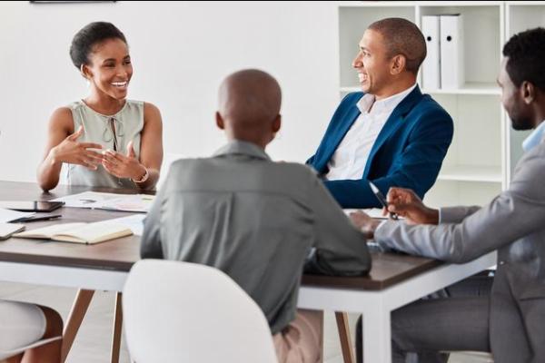 a group of colleagues sat around a table discussing ideas and development