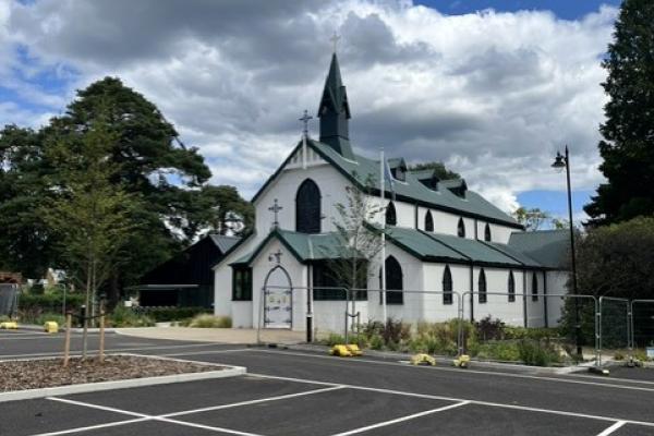 White church, cap parking spaces in foreground