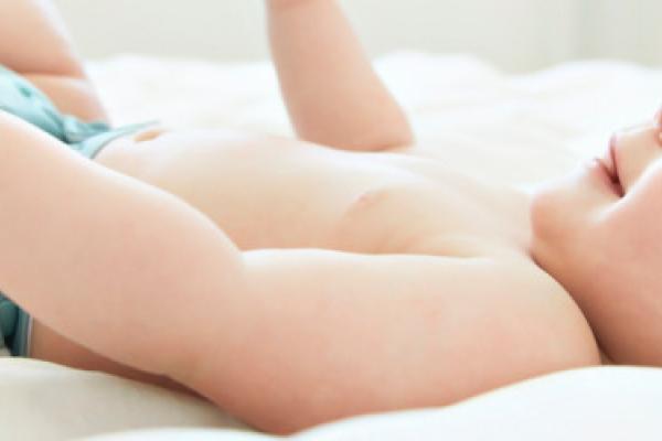 A baby lying on a bed.
