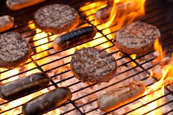 Burgers and sausages cooking on a bbq