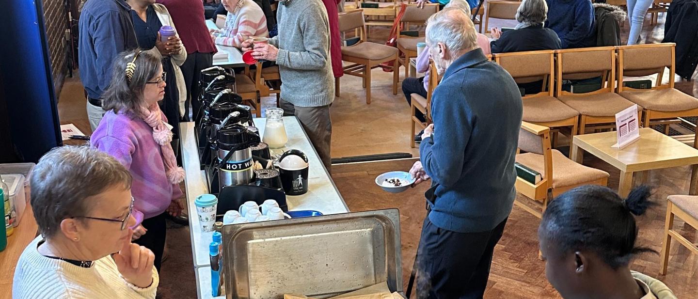 people serving breakfast at the breakfast church event with attendees chatting and eating their breakfast
