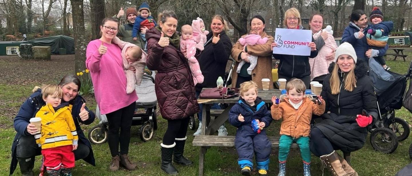group of parents and their children sat around picnic benches at Frimley Lodge Park