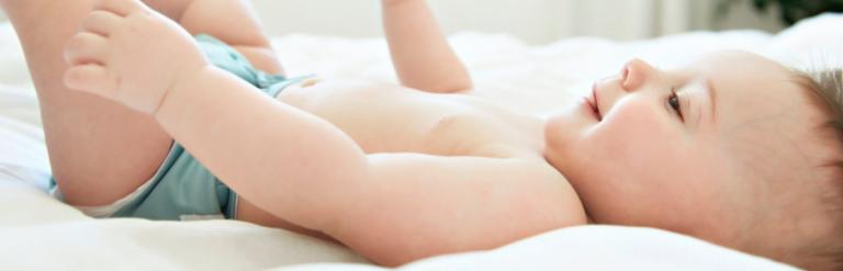 A baby lying on a bed.