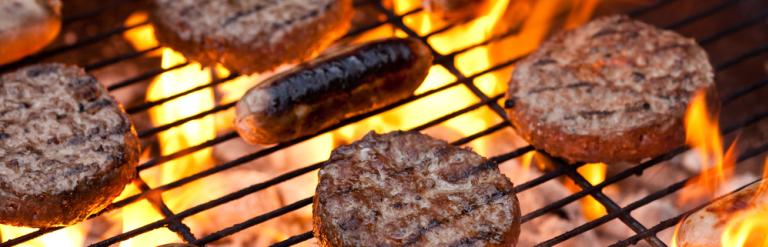 Burgers and sausages cooking on a bbq