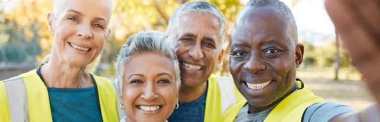diverse group of people with high vis jackets in a park