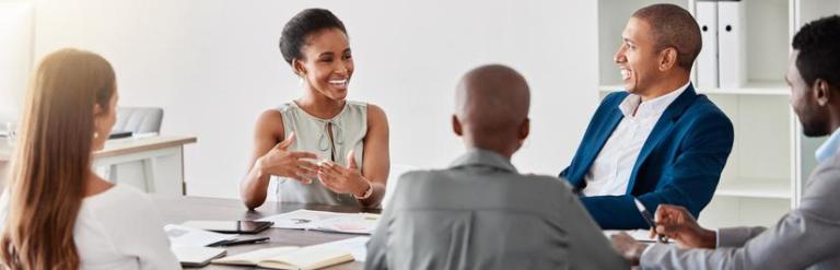 a group of colleagues sat around a table discussing ideas and development