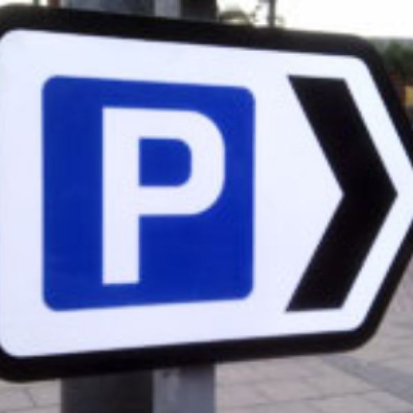 White parking sign with blue square with white P inside and black arrow pointing to right
