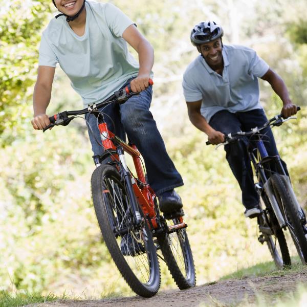 A family cycling along a trail on a sunny day