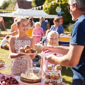 Children serving cake on a stall at a community picnic