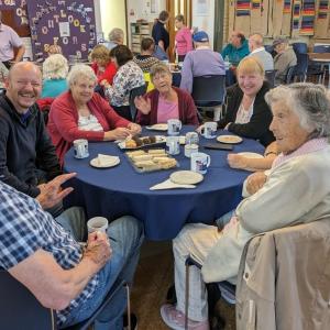 group of adults at the senior outlook event sitting around a table chatting